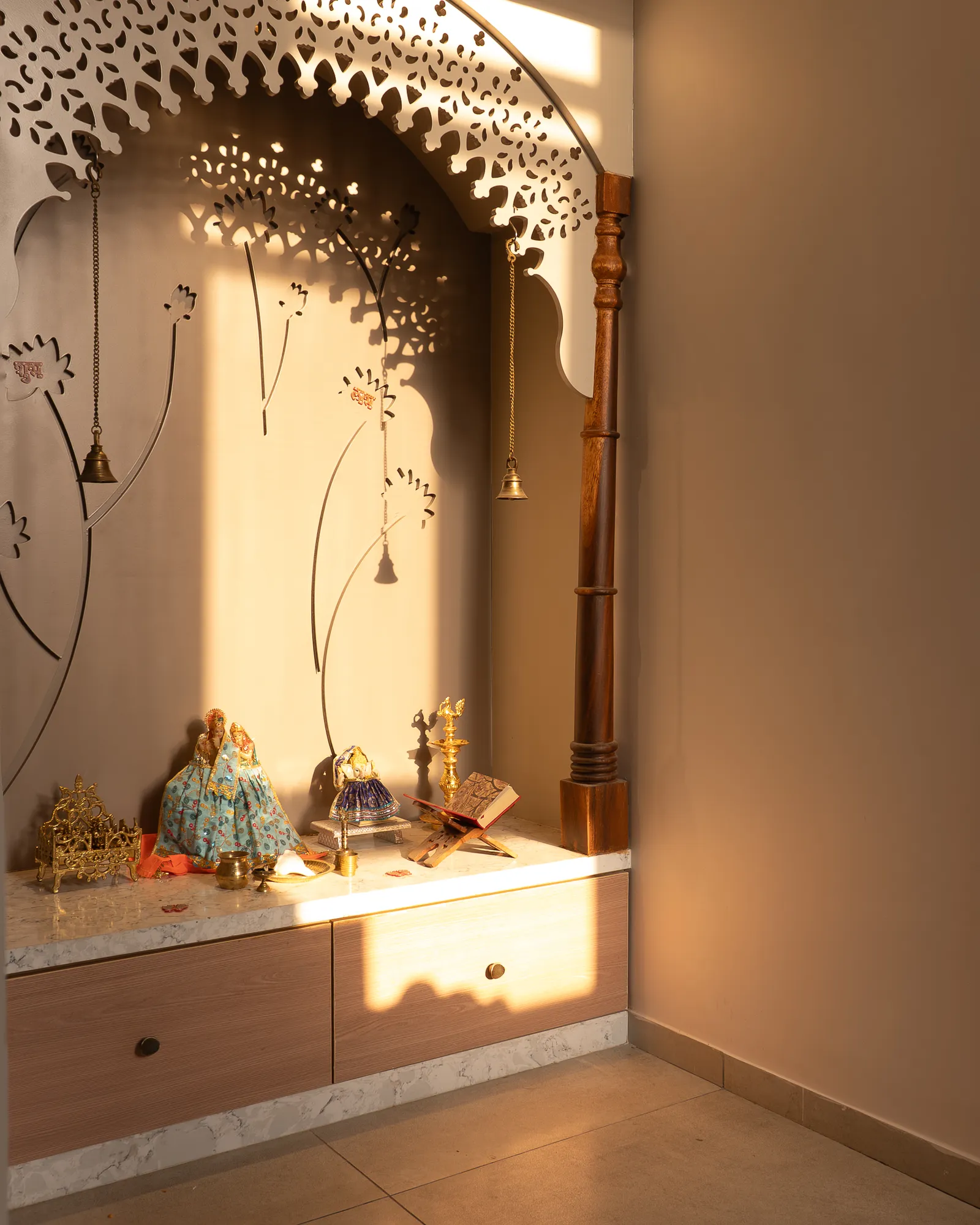 Pooja niche with carved arch, lit by sunlight — Amlan's Residence